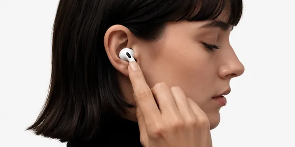 Woman adjusting AirPods, light studio