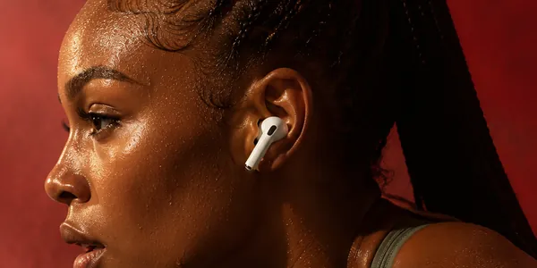 Athlete wearing AirPods against a red backdrop