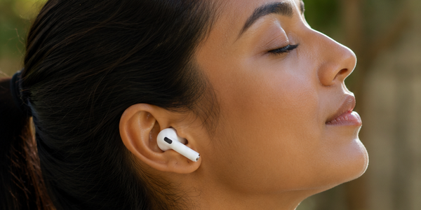 Woman wearing AirPods outdoors in soft light