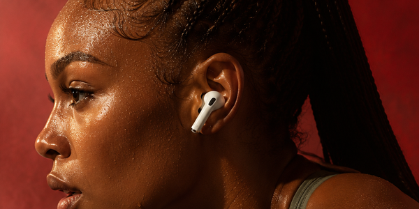Athlete wearing AirPods against a red backdrop